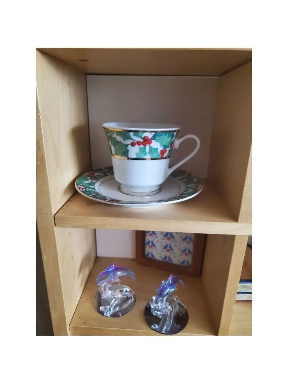 vintage teacup and saucer set features a festive holly pattern.